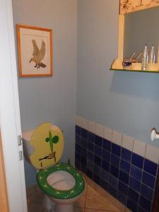 ein Badezimmer mit einem WC mit einer Pflanze darauf in der Unterkunft Le Moulin des Prés in Vesoul