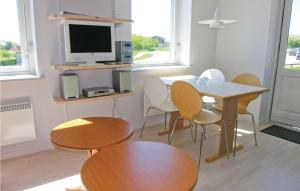 um quarto com uma mesa e cadeiras e um monitor de computador em Mlleparken em Gudhjem