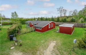 a red house in a yard with a fence at Lovely Home In Hadsund With Kitchen in Hadsund