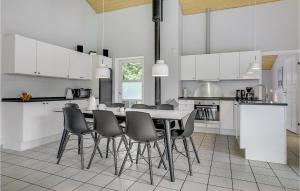 a white kitchen with a table and chairs at Lovely Home In Væggerløse With Wifi in Marielyst