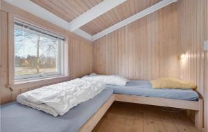 a bed in a room with a window at Nice Home In Grenaa With Kitchen in Stokkebro