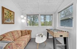a living room with a couch and a foosball table at Holiday Home Ildervej Yellow in Hemmet +16 photos