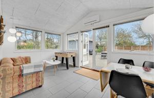 a living room with a couch and a table at Holiday Home Ildervej Yellow in Hemmet