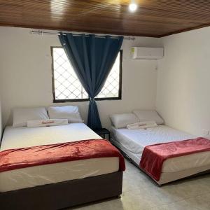 een slaapkamer met 2 bedden en een raam bij Casa Salmón Confortable Casa Completa in Valledupar