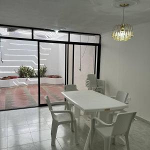 a dining room with a white table and chairs at Casa Salmón Confortable Casa Completa in Valledupar