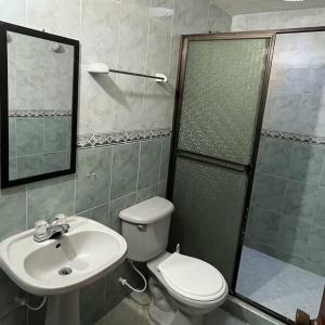 een badkamer met een toilet, een wastafel en een douche bij Casa Salmón Confortable Casa Completa in Valledupar