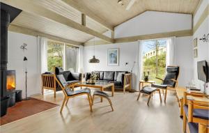 sala de estar con sofá, sillas y chimenea en Nice Home In Nrre Nebel With Sauna, en Nymindegab