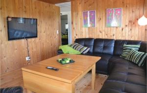 uma sala de estar com um sofá de couro preto e uma mesa em Beautiful Home In Tarm With Kitchen em Fjerbæk