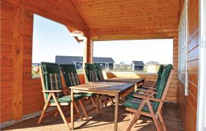 a wooden table and chairs on a deck at Holiday Home Sydals 16 With Hot Tub in Skovby