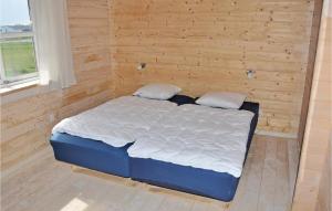 a bed in a room with a wooden wall at Holiday Home Sydals 16 With Hot Tub in Skovby +4 photos