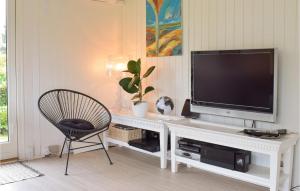 een woonkamer met een tv en een stoel bij Beautiful Home In Grsted With Wifi in Udsholt Sand