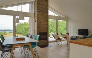 sala de estar con mesa, sillas y chimenea en Beautiful Home In Skals With Wifi, en Skals