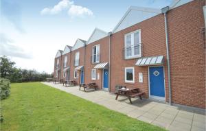 a row of brick buildings with picnic tables in the courtyard at Holiday Home Vadehavsvej Højer V in Emmerlev