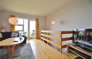 a living room with a couch and a tv and a table at Nice Home In Hjer With Kitchen in Emmerlev