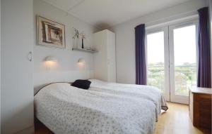 Nice Home In Hjer With Kitchen في Emmerlev: غرفة نوم بيضاء بها سرير ونافذة