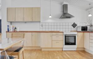 a kitchen with wooden cabinets and a stove top oven at Imagine in Bedegård