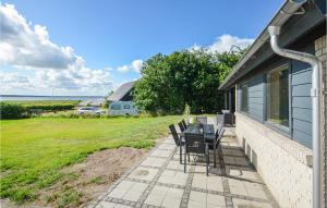 a patio with chairs and a table on the side of a house at Cozy Home In Øster Assels With Wifi in Øster Assels