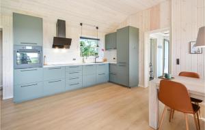 uma cozinha com armários azuis e uma mesa de jantar em Pet Friendly Home In ster Assels With Wifi em Øster Assels