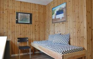 Cette chambre comprend un lit dans un mur en bois. dans l'établissement Nice Home In Kirke Hyllinge With Wifi, à Kirke-Hyllinge