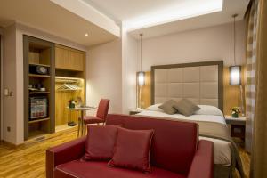 una camera d'albergo con un letto e un divano rosso di Vibe Nazionale a Roma