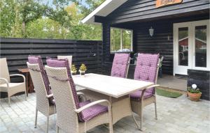 a table with purple chairs on a patio at Two-Bedroom Holiday Home In Ansager in Ansager
