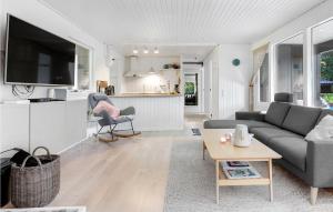 a living room with a couch and a table at Amazing Home In Aakirkeby With House Sea View in Vester Sømarken