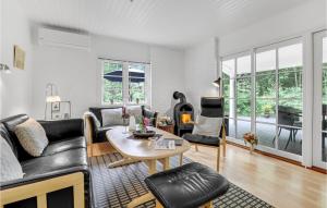 a living room with black leather furniture and a table at Baluka in Bedegård