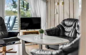 a living room with chairs and a table and a tv at Holiday Home Ringvejen Rømø I in Bolilmark