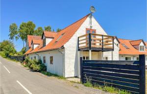 a white house with an orange roof and a fence at Beautiful Apartment In Gudhjem With Wifi in Gudhjem