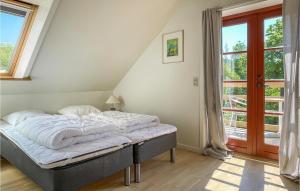 a bed in a room with a large window at Beautiful Apartment In Gudhjem With Wifi in Gudhjem