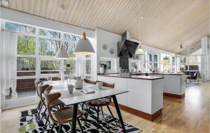 Rubinsen Skovhuse في Tofte: مطبخ وغرفة معيشة مع طاولة وكراسي