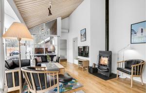 a living room with a table and a fireplace at Rubinsen Skovhuse in Tofte