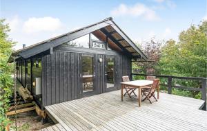 ein schwarzes winziges Haus mit einem Tisch auf einer Terrasse in der Unterkunft Amazing Home In Tisvildeleje With Kitchen in Tisvildeleje