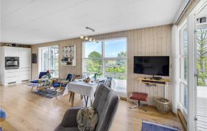 ein Wohnzimmer mit einem Tisch und Stühlen sowie einem TV in der Unterkunft Nice Home In Augustenborg With Sauna in Asserballeskov