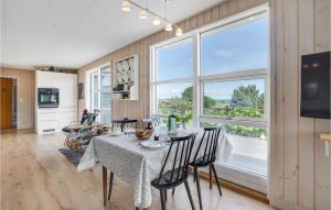 a dining room with a table and a large window at Nice Home In Augustenborg With Sauna in Asserballeskov