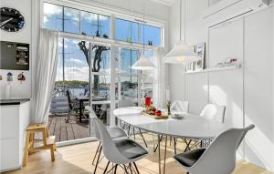een keuken en eetkamer met een witte tafel en stoelen bij Muslingen 721 in Ebeltoft