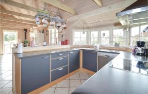 cocina grande con armarios azules y ventanas en Amazing Home In Vggerlse With 2 Bedrooms And Internet, en Bøtø By
