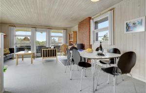 Bjerregårdにある3 Bedroom Amazing Home In Hvide Sandeのリビングルーム(テーブル、椅子付)