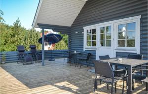 una terraza con sillas, una mesa y una sombrilla en Lovely Home In Hovborg With Kitchen, en Hovborg