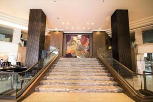 a staircase in a building with a mural on the wall at Centara Udon in Udon Thani