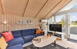 a living room with a blue couch and a table at Holiday Home Kirksvej Hvide Sande Iv in Bjerregård