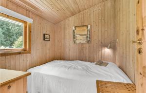 Bett in einem Holzzimmer mit Fenster in der Unterkunft Paradiset in Skattebølle