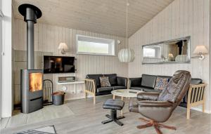 sala de estar con sofá y chimenea en Nice Home In Rdekro With 3 Bedrooms And Wifi en Diernæs