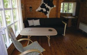 SpidsegårdにあるPet Friendly Home In Nex With Kitchenのソファ、テーブル、壁に牛が備わる客室です。