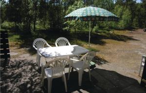 a table with two chairs and an umbrella at Stunning Home In Nex With 2 Bedrooms And Wifi in Spidsegård