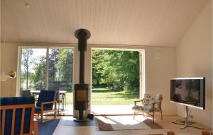 Tikøb的住宿－Amazing Home In Tikb With Kitchen，客厅设有壁炉和电视。