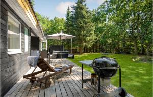 un patio con parrilla, silla y mesa en Stunning Home In Ebeltoft With Kitchen, en Øksenmølle