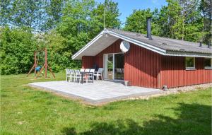 eine rote Scheune mit einem Tisch und Stühlen sowie einem Spielplatz in der Unterkunft Amazing Home In Oksbl With 3 Bedrooms And Wifi in Oksbøl