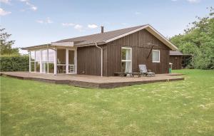 a small house with a porch and a deck at Awesome Home In Vinderup With Wifi in Vinderup +14 photos