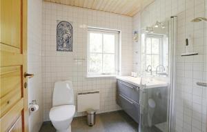 a white bathroom with a toilet and a sink at Tefres in Snogebæk